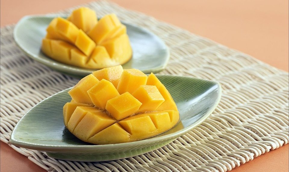 Sliced mangoes on green dishes, ready to serve.