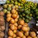 Tropical fruits and roots displayed in a vibrant market setting.