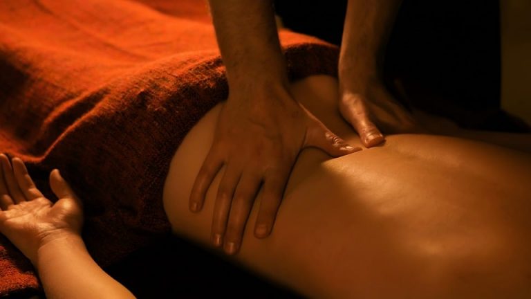 Massage therapist performing back massage therapy.