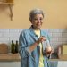 Senior woman preparing a smoothie in her kitchen.