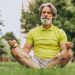 Senior man meditating in park, enjoying mindfulness.