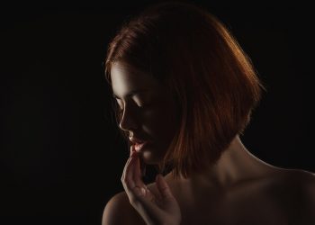 Shadows highlight a woman's contemplative profile.