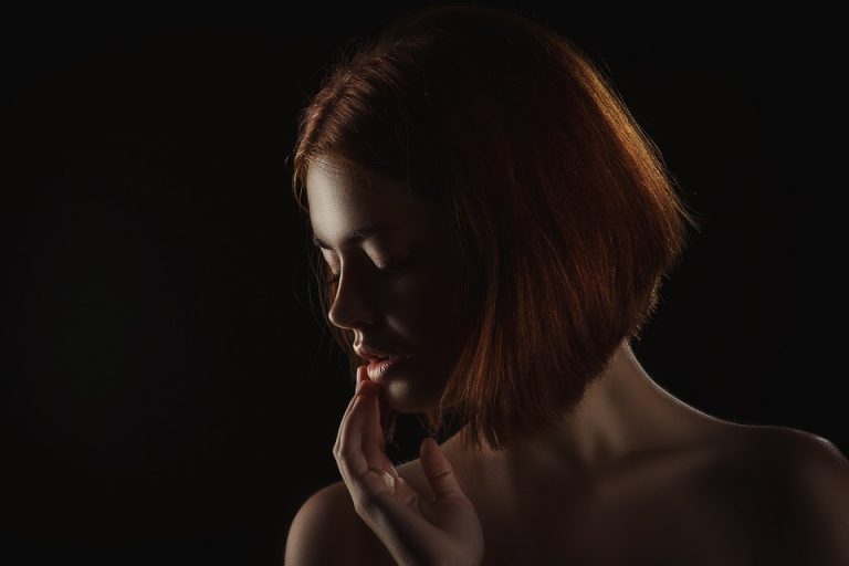Shadows highlight a woman's contemplative profile.