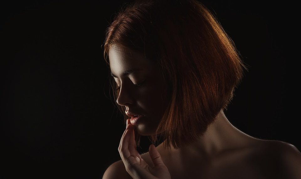 Shadows highlight a woman's contemplative profile.
