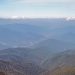 Mountain range view under blue sky with scattered clouds.