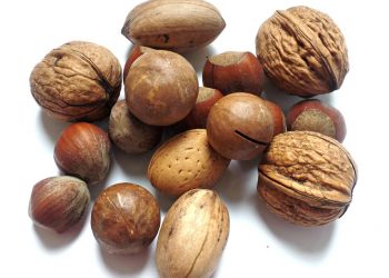 Various nuts including walnuts and almonds on a white background.