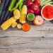Fresh fruits and vegetables neatly arranged on a rustic wooden table.
