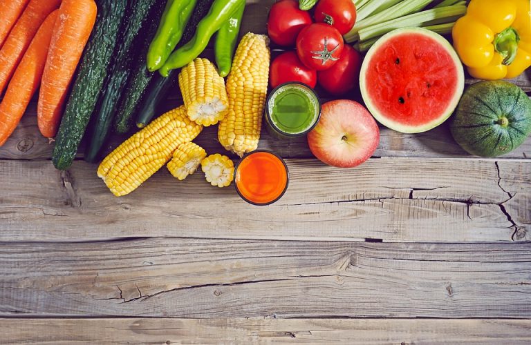 Fresh fruits and vegetables neatly arranged on a rustic wooden table.