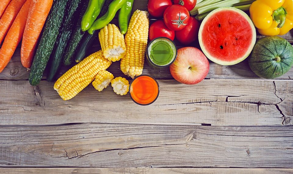 Fresh fruits and vegetables neatly arranged on a rustic wooden table.