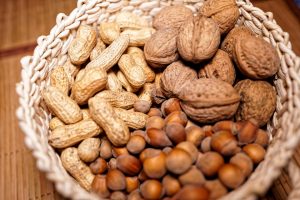Basket filled with assorted nuts including peanuts, walnuts, and hazelnuts.