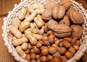 Basket filled with assorted nuts including peanuts, walnuts, and hazelnuts.