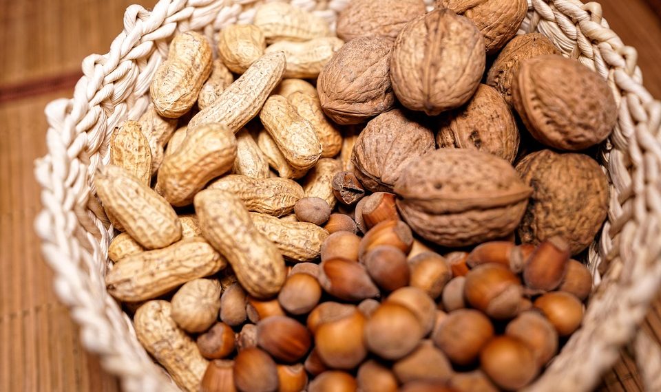 Basket filled with assorted nuts including peanuts, walnuts, and hazelnuts.
