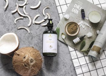 Coconut oil product with coconut slices and skincare magazine.