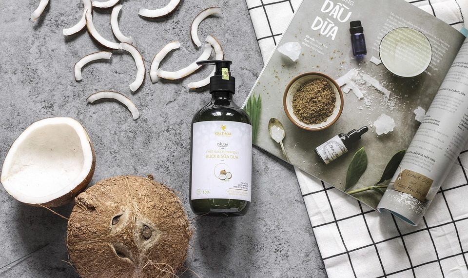 Coconut oil product with coconut slices and skincare magazine.