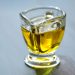 Golden olive oil in a glass container on a table.