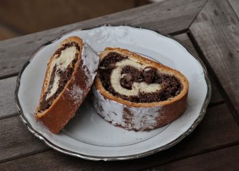 Two slices of chocolate swirl cake on a white plate.
