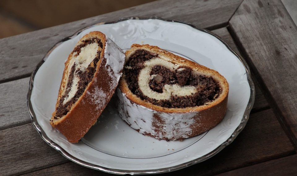 Two slices of chocolate swirl cake on a white plate.