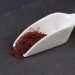 Saffron threads on a white scoop utensil.