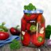 Jar of pickled tomatoes with parsley and garlic cloves.