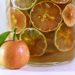 Tangerine and citrus slices in infused drink jar.