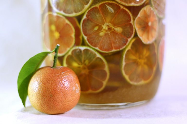 Tangerine and citrus slices in infused drink jar.