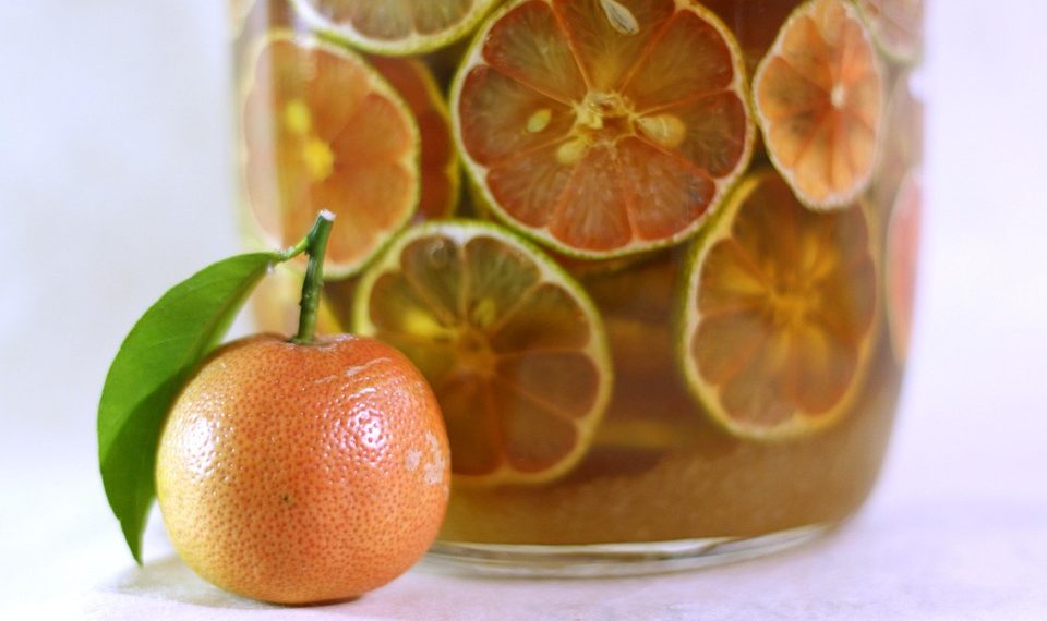 Tangerine and citrus slices in infused drink jar.