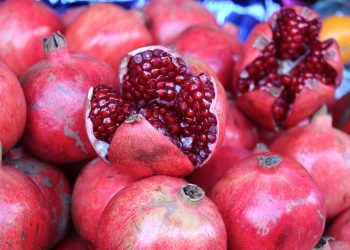 Pomegranate display with open fruit showing seeds.