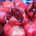 Pomegranate display with open fruit showing seeds.