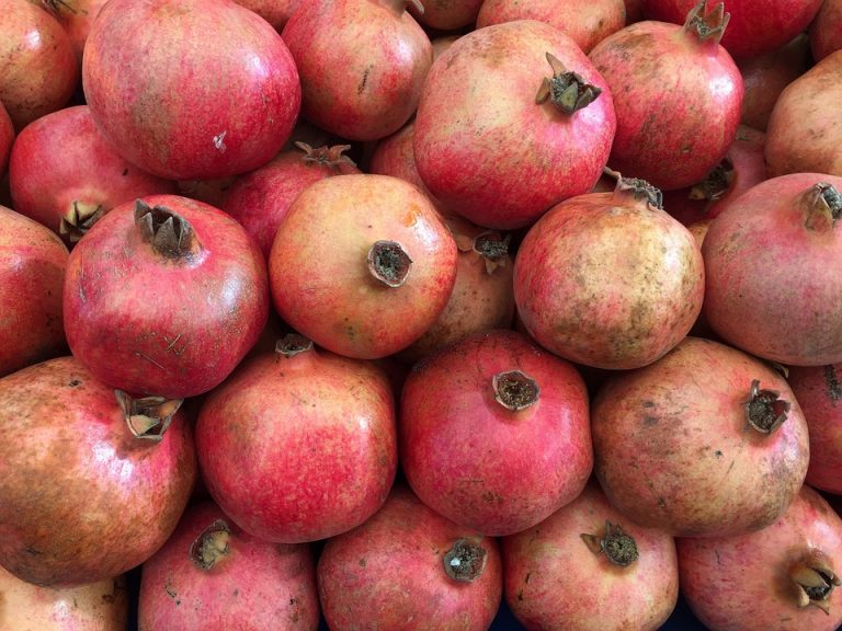 Cluster of fresh pomegranates with vibrant red color.
