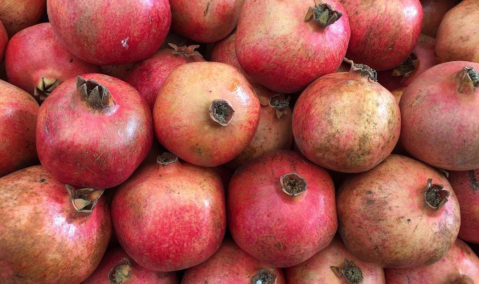 Cluster of fresh pomegranates with vibrant red color.