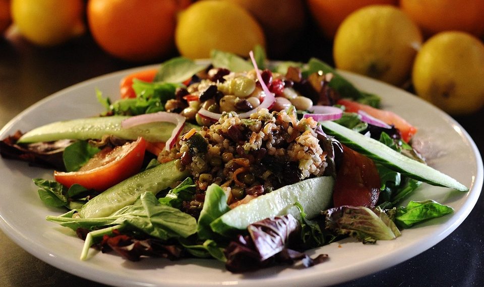 Fresh mixed salad with cucumbers, tomatoes, and grains.