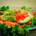 Fresh salad with lettuce, tomato, and avocado slices on a plate.