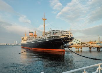 Docked historical ship at harbor during evening light.