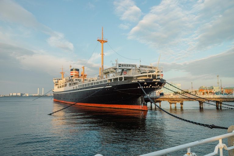 Docked historical ship at harbor during evening light.