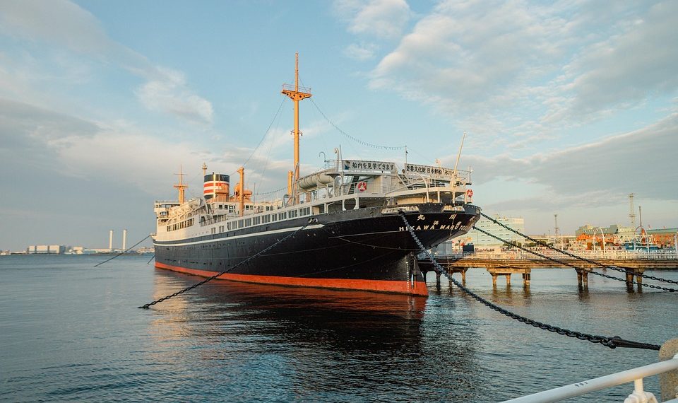 Docked historical ship at harbor during evening light.