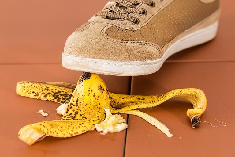 Shoe about to step on a banana peel, creating a potential slip hazard.