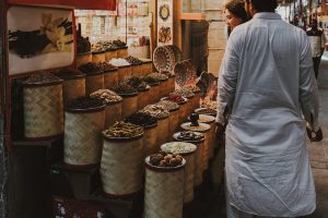 Spice vendor with colorful display at a bustling market.