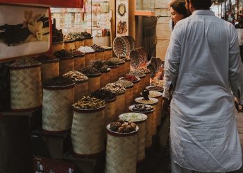 Spice vendor with colorful display at a bustling market.