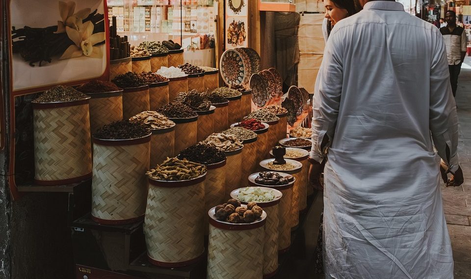 Spice vendor with colorful display at a bustling market.