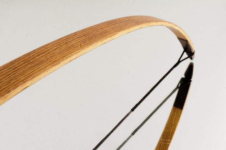 Wooden recurve bow detail with smooth curve design.