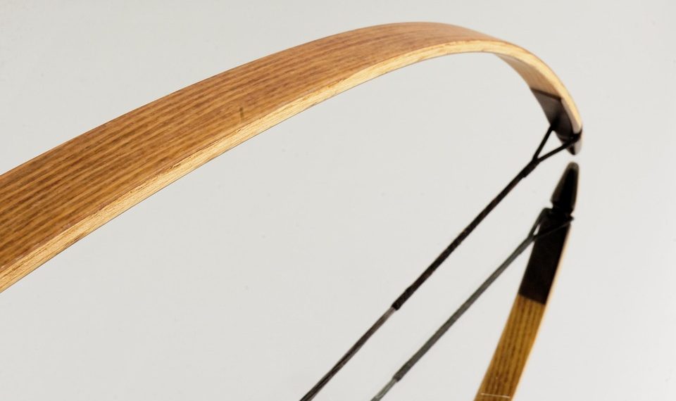 Wooden recurve bow detail with smooth curve design.