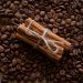 Cinnamon sticks tied with twine on coffee beans background.