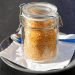 Jar of brown sugar on a plate with spoon.