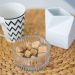 Chevron mug with sugar cubes in bowl on woven placemat.