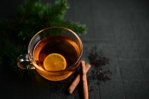 Lemon tea with cinnamon on a dark background.