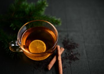 Lemon tea with cinnamon on a dark background.