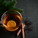 Lemon tea with cinnamon on a dark background.