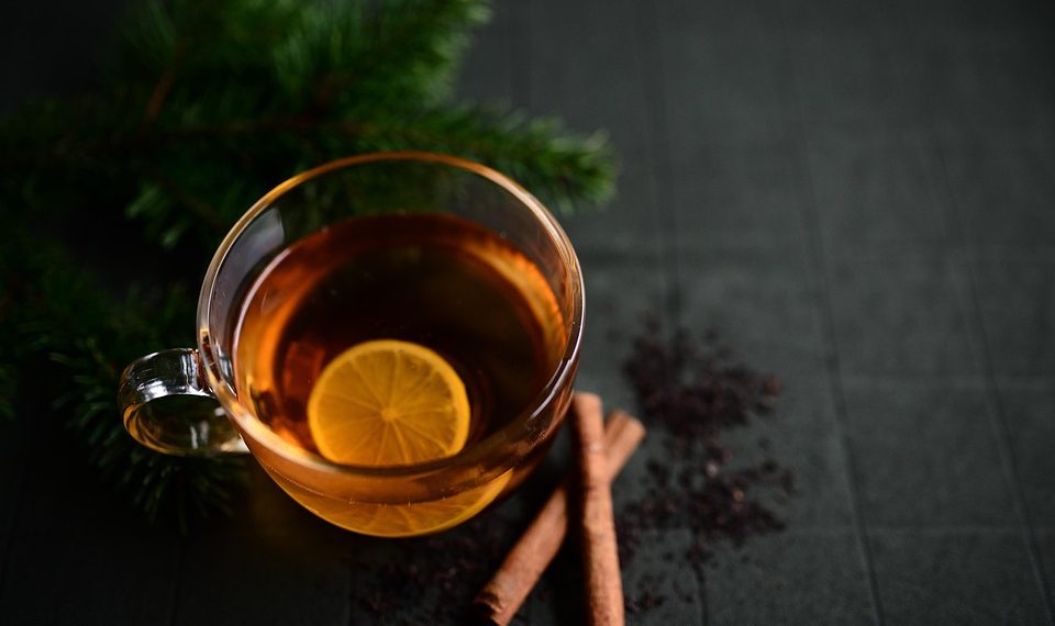 Lemon tea with cinnamon on a dark background.