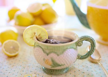 Steaming herbal tea in a decorated cup with lemon slice.