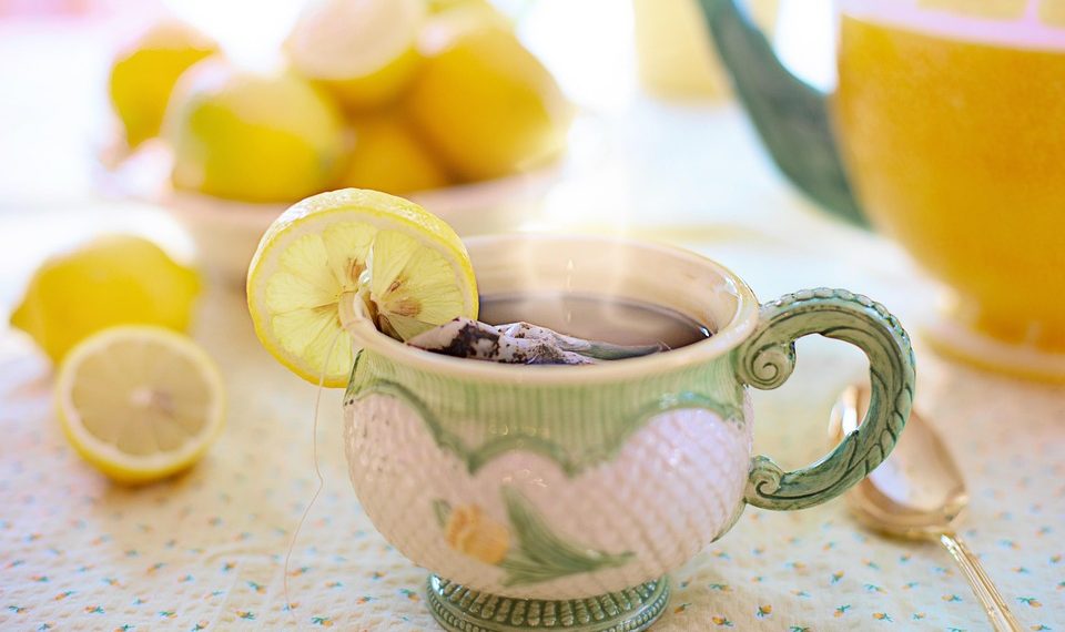 Steaming herbal tea in a decorated cup with lemon slice.